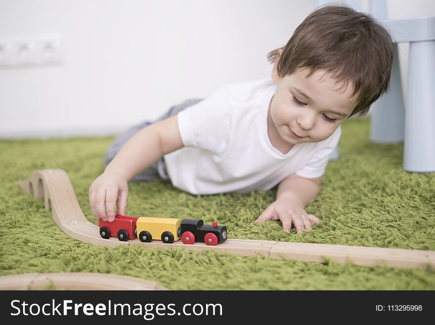 Small toddler in a colorful children room in a nursery or preschool. child boy playing with toys indicators at home