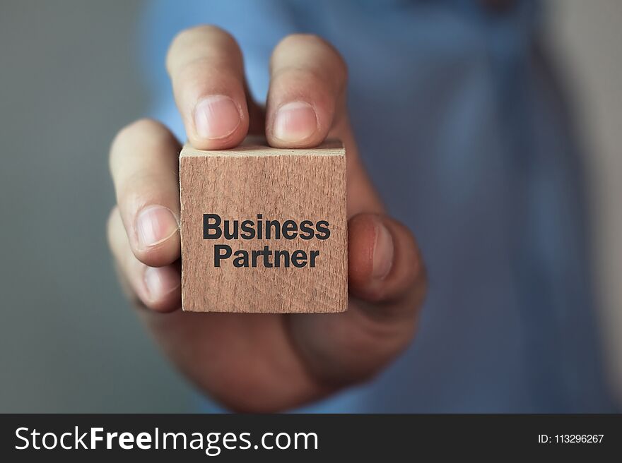Man showing Business Partner text on wooden cube. Business
