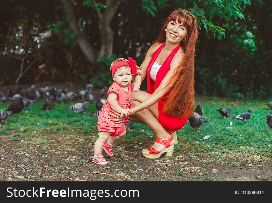 Happy mother and daughter in the park. Beauty nature scene with family outdoor lifestyle. Happy mother and daughter in the park. Beauty nature scene with family outdoor lifestyle.