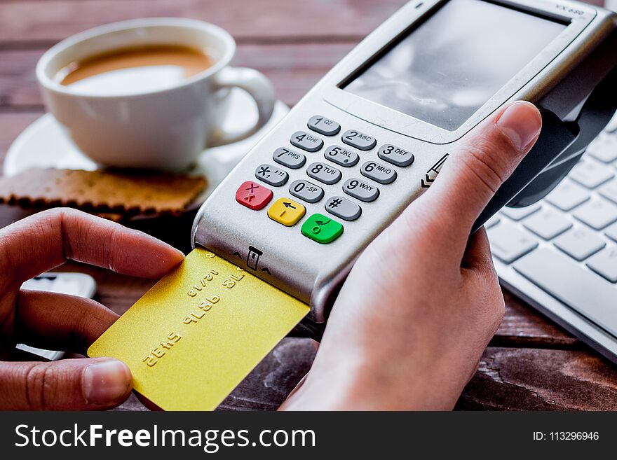 Payment in cafe concept with card and terminal on wooden backgro