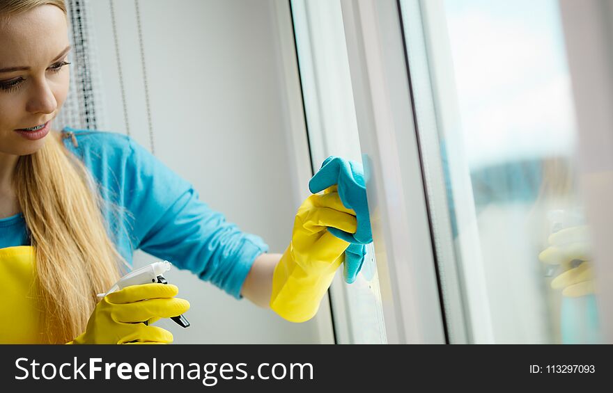 Girl Cleaning Window At Home Using Detergent Rag