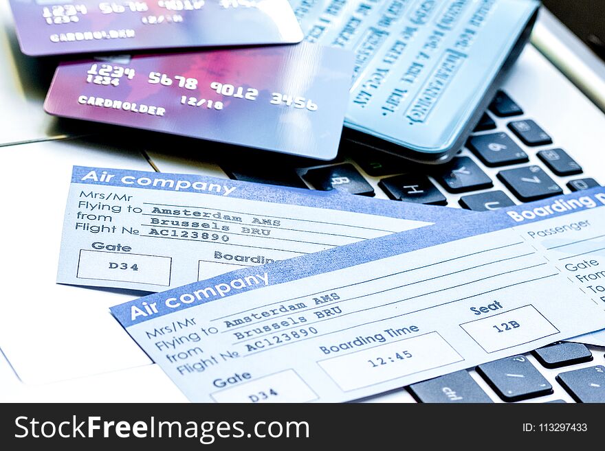 Credit cards with airline tickets for vacations on laptop backgr