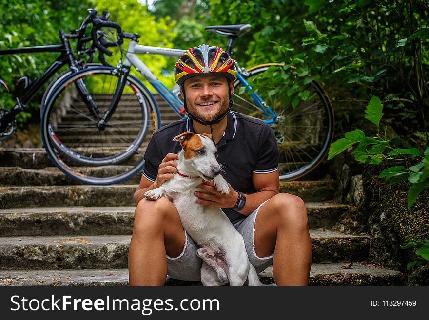 Male posing with his russel dog on stairs.