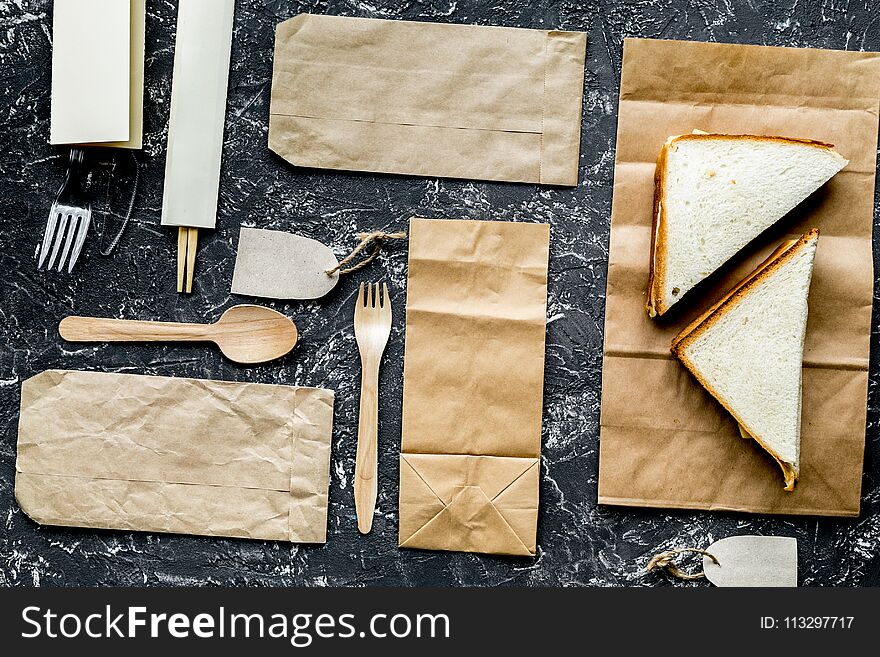 Food delivery with paper bags and sandwich on gray background to