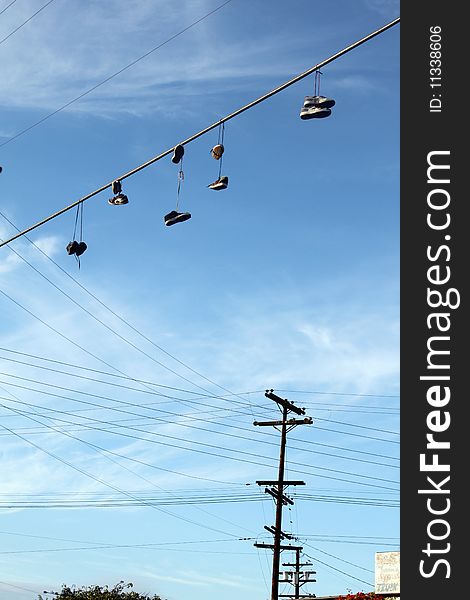 Shoes hanging from shoelaces on power cable. Shoes hanging from shoelaces on power cable