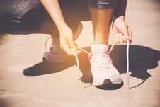 Hands Of A Young Woman Shoelace And Sneakers. Shoes Standing On Stock Images