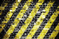 Old And Weathered Grungy Brick Wall With Danger Or Attention Black And Yellow Diagonal Stripes As Texture Background. Royalty Free Stock Photo