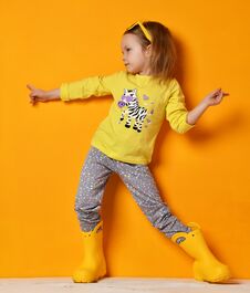 Young Child Baby Girl Kid In Yellow Rubber Boots Sunglasses And T-shirt Posing On Yellow Royalty Free Stock Photos