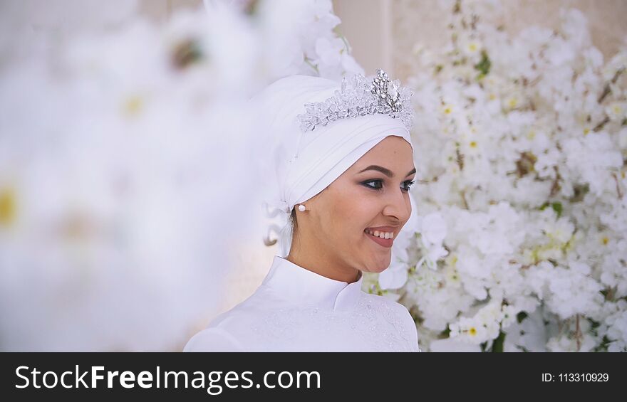 Smiling muslim bride with bridal make up in flowers