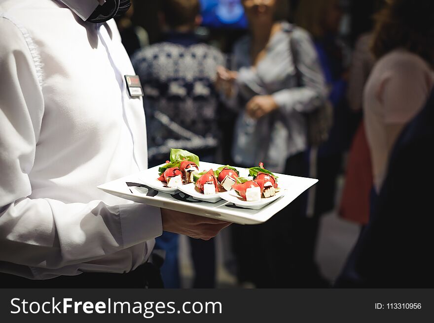 Waiter carrying trays with food. Caterring service for wedding, birthday or any company event.