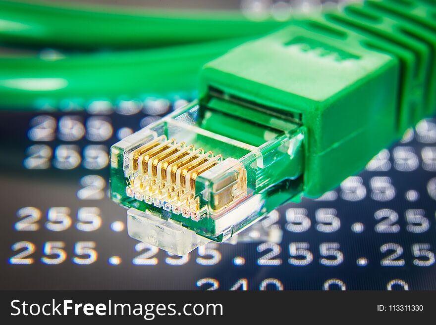 Green ethernet cable detail. Routing table on the background.