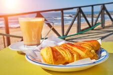 Coffee Cup With Croissant On Table In Cafe Terrace And View On The Sea With Waves Royalty Free Stock Images