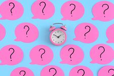 Pink Stickers With Question Marks. A Small Pink Alarm Clock In The Center. Bright Photo From The Top. Stock Image
