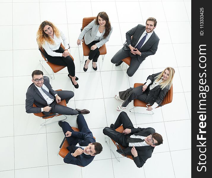 View from the top.successful business team sitting in a circle and looking at the camera.