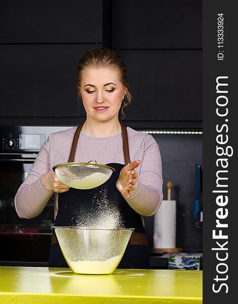 Pretty woman standing in kitchen and cooking bakery. Pretty woman standing in kitchen and cooking bakery