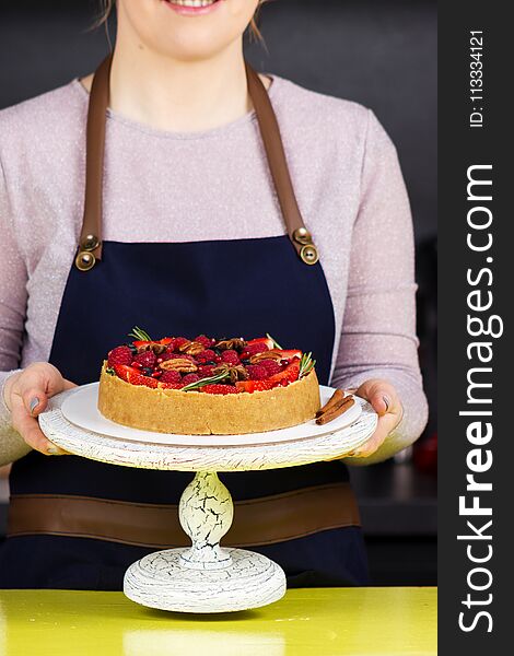 Woman standing with cheesecake and smiling in kitchen. Woman standing with cheesecake and smiling in kitchen