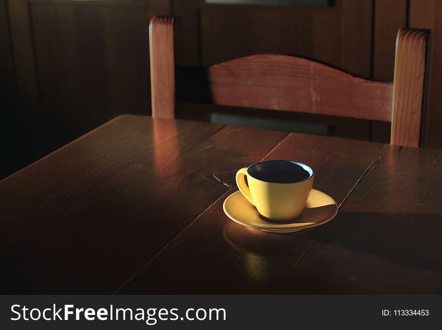 A Yellow Cup Of Coffee, With A Soft Ray Of Moonlight