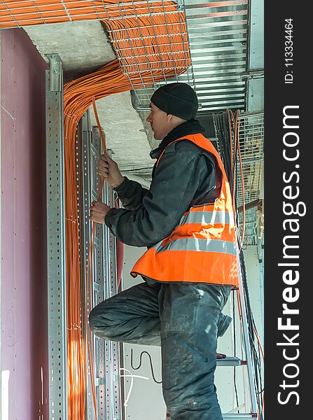 The process of fastening a yellow cable for the Internet in the new office space