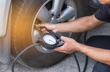 Mechanic Inflating Tire And Checking Air Pressure With Gauge Pressure Stock Images