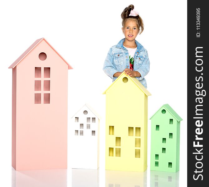 Little girl is playing with wooden houses.