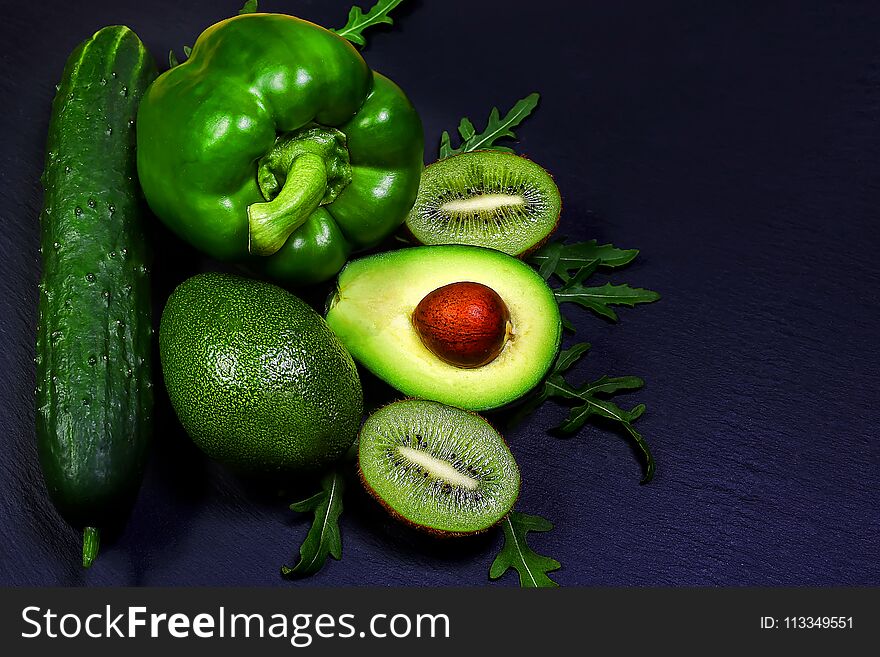 Green assortment vegetables and fruits, avocados, kiwi, pepper and cucumber on a shale board, the concept of healthy eating, copy space, top view set.