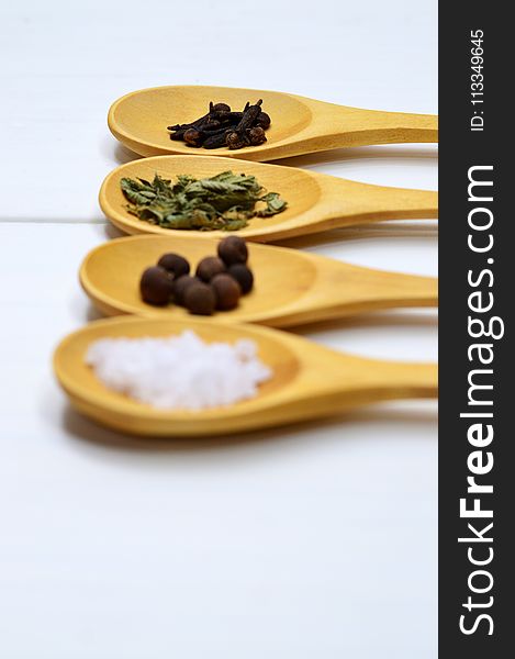 Four Assorted Spices On Brown Wooden Spoon