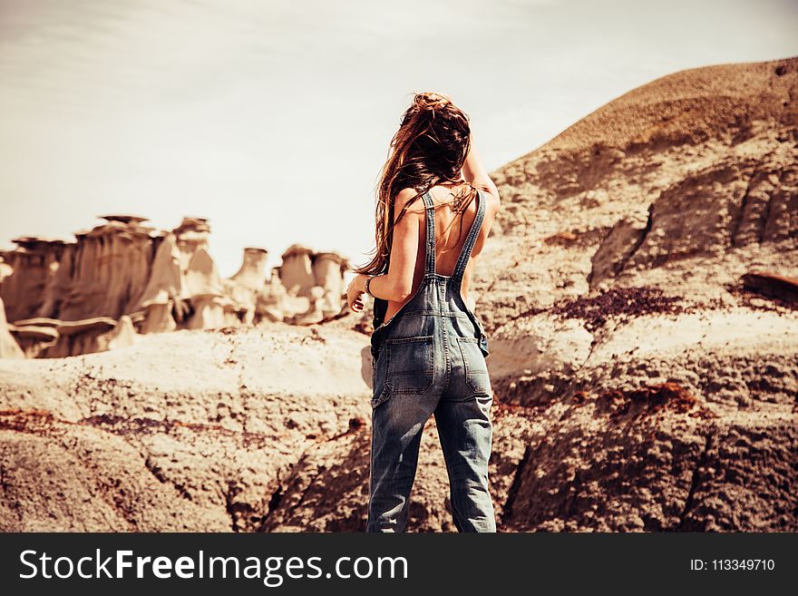 Woman Wearing Blue-washed Overalls Near Rock Formation