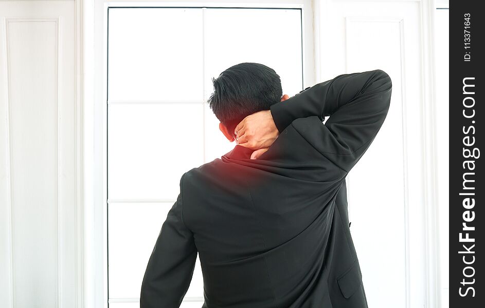 Businessman suffering from shoulder pain in office