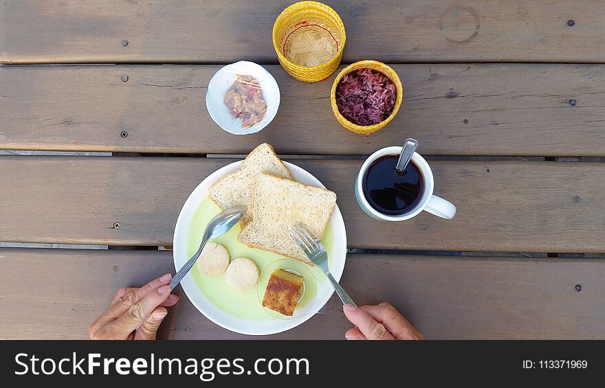 Top view man having breakfast on wooden table at home. Top view man having breakfast on wooden table at home