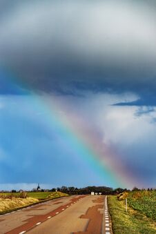 Beautiful Colorful Rainbow At The End Of Asphalt Road, Perspective View Stock Photos