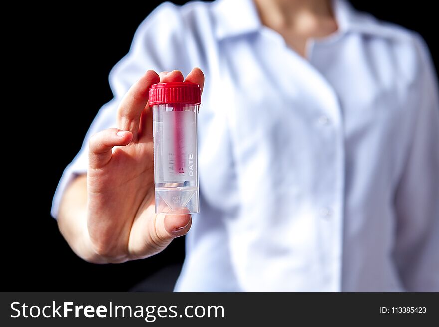 Close of woman hands holding sterile sample Container bottle for medical analysis. Health care and medical concept.