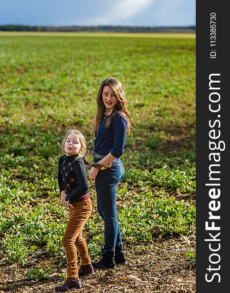 Two sisters happy with the nature, springtime in the field, France