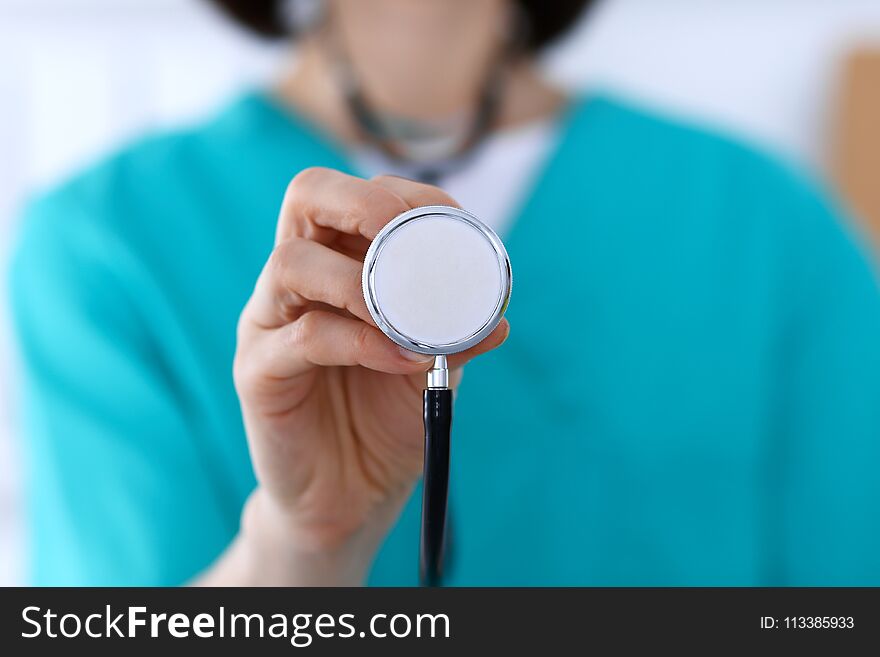 Female doctor holds stethoscope head closeup. Physicians ready to examine and help patient. Medical help and insurance