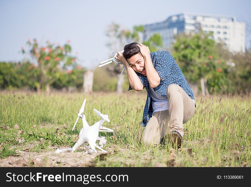 Man feel bad with crashed drone in the park. Man feel bad with crashed drone in the park