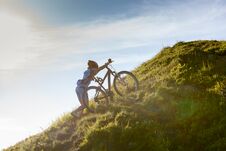 Biker Pushes Bicycle Up In The Mountains Stock Photos