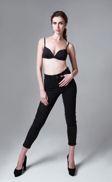 Studio Fashion Shot: Portrait Of Attractive Young Woman In Pants And Bra. Full Length Stock Photo