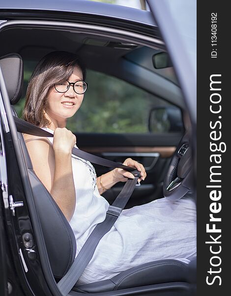 Asian woman fasten car seat belt before take a driving