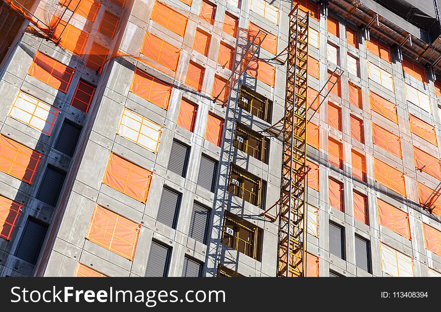 Construction crane column and concrete house under construction. Block of flats development