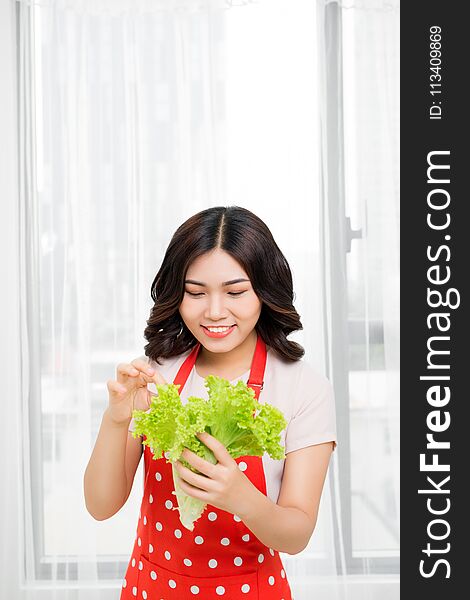 Picture of happy woman with lettuce in kitchen.