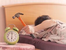 Beating The Alarm Clock With Hammer. Concept Of Sleep Royalty Free Stock Photos