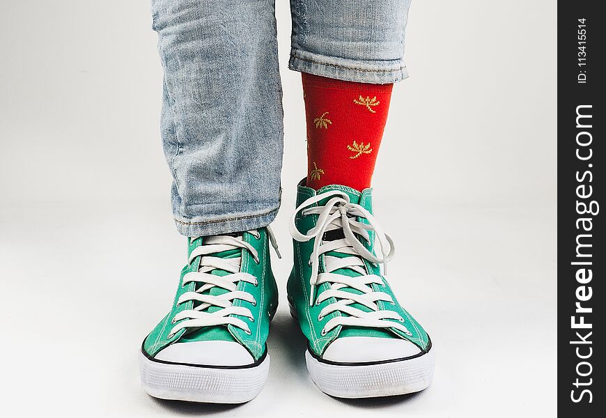 Stylish, bright, green sneakers and funny, happy socks on a white background. Sport, style, beauty, good mood. Stylish, bright, green sneakers and funny, happy socks on a white background. Sport, style, beauty, good mood