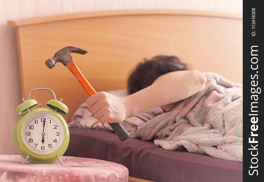 Beating the alarm clock with hammer. concept of sleep