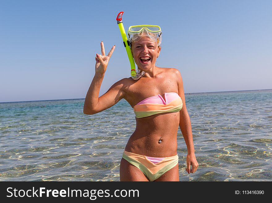 Cheerful woman wearing snorkeling mask standing in Red Sea