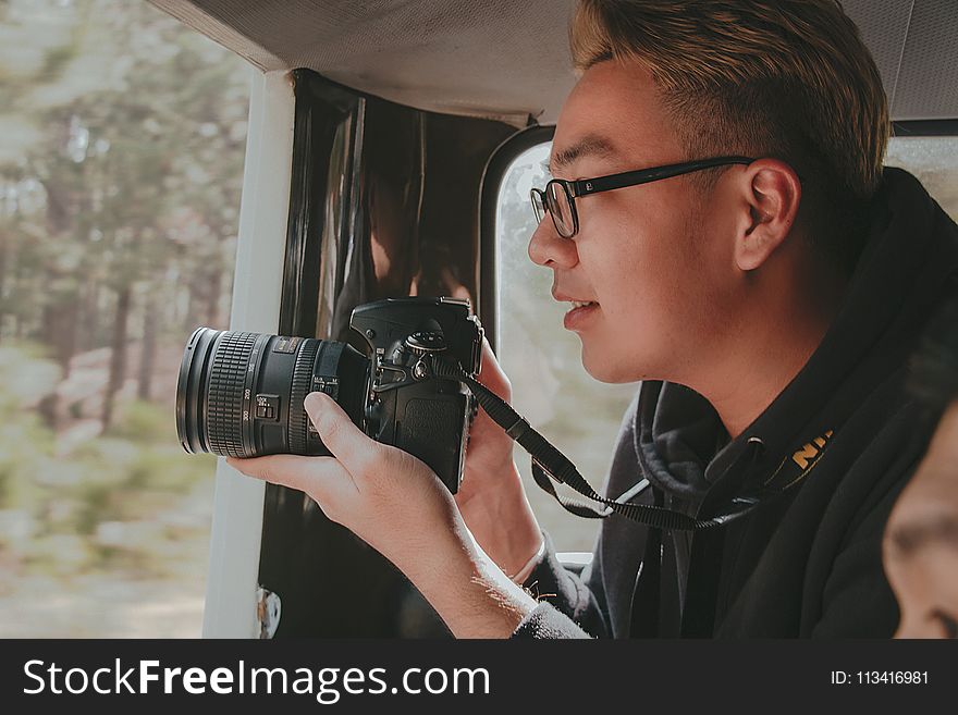 Photo of Man Holding Nikon Dslr Camera