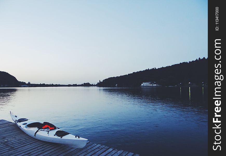 White Kayak On Brown Wooden Dock