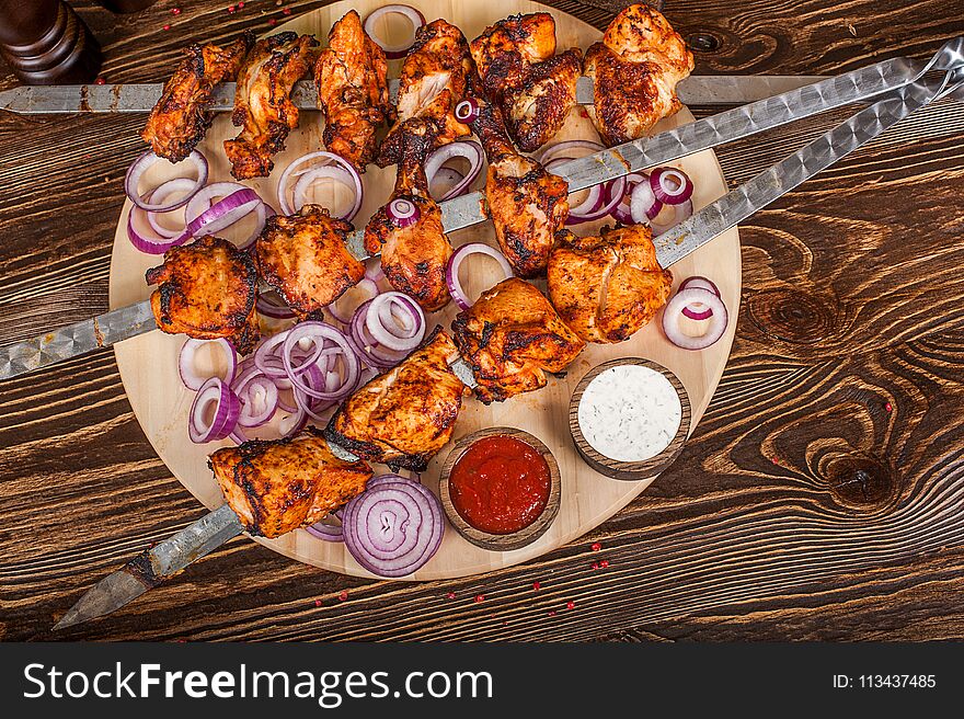 Barbecue shish kebabs - grilled meat on wooden background. Barbecue shish kebabs - grilled meat on wooden background