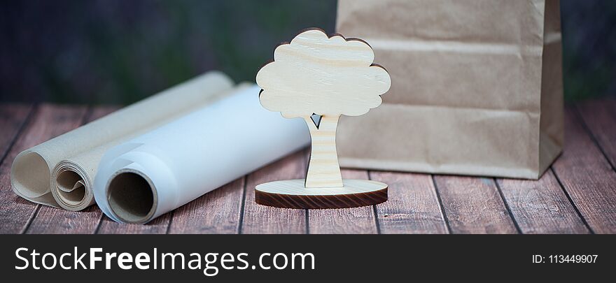 Concept save the forest, trees. Creative shot of a small tree and paper rolls on a natural background of lavender field.