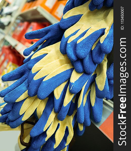 New colored work gloves on the shelf of the store