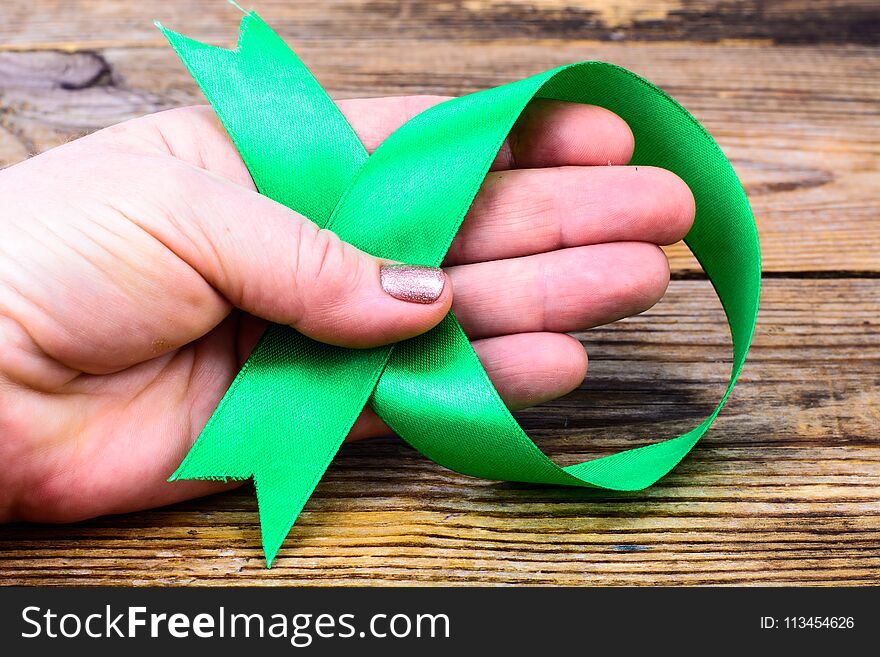 Green ribbon as symbol of awareness of the disease, World Health Day. Studio Photon