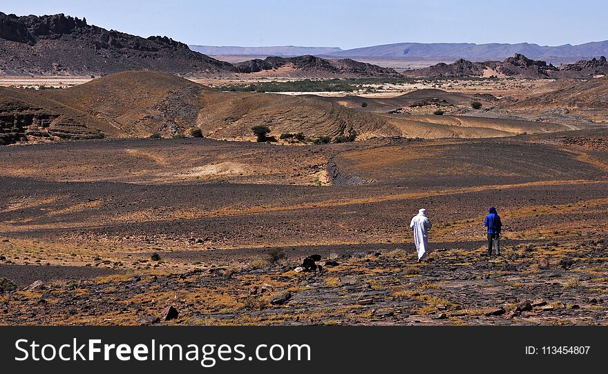 Rocky, mountainous hot and dry Sahara in Morocco with two outgoing people.